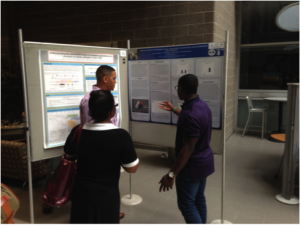 Undergraduates Quincy Cunningham and Herve Nonga explain MIC experiment results to Dr. Chandra Jack at Annual BEACON Congress, 2014.