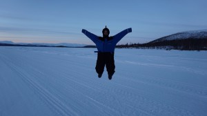 René enjoying the midday sun on a frozen lake above the Arctic Circle.